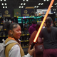 A woman holds a lightsaber at NYCC